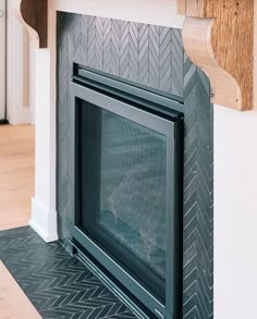 a fireplace with a black mantle and white trim on the top, along with an oak mantel