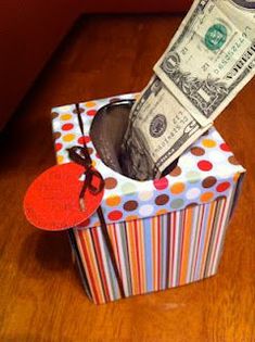 a dollar bill sticking out of a gift box