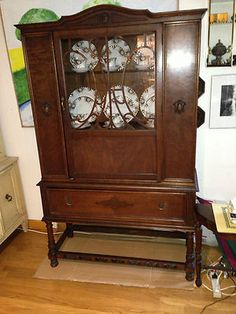 a grandfather clock sitting on top of a wooden cabinet