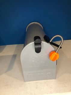 an orange object is attached to the side of a white container