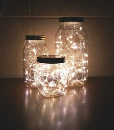 three mason jars with fairy lights in them