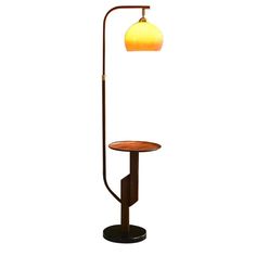 a lamp that is sitting on top of a wooden stand with a light bulb attached to it