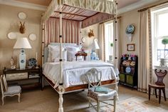 a bedroom with a canopy bed and chairs