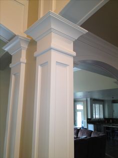 a living room filled with furniture and white columns