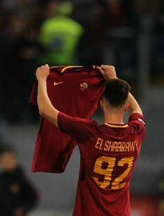 a man holding up a jersey in front of his face