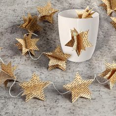 some paper stars are laying next to a cup