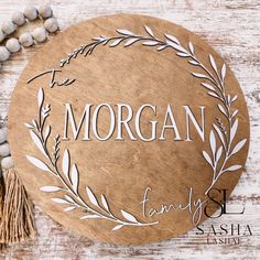 a wooden plaque with the words morgan family on it next to a beaded necklace