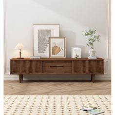 a living room with a white rug and some pictures on the wall next to it