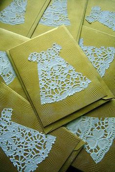 yellow and white paper with lace doily on them are laid out in the shape of an ornament