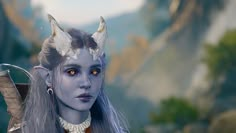 a woman with long gray hair and horns on her head is standing in front of mountains