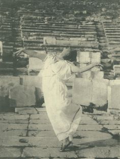 an old black and white photo of a woman dancing in front of some stone steps