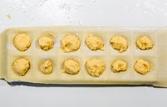 doughnut holes in an uncooked pan on a white counter top, ready to be baked