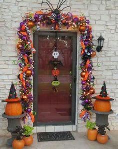 a front door decorated for halloween with pumpkins and decorations