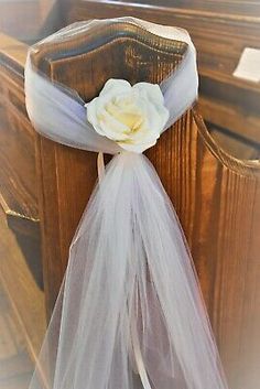 a white flower is placed on the back of a church organe chair sasher