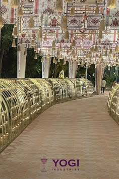 the walkway is lined with gold colored metal bars and chandeliers hanging from them