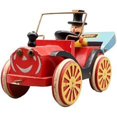 an old fashioned toy car with a man riding in it