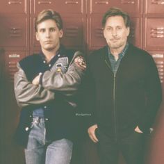 two men standing next to each other in front of lockers