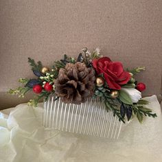 a hair comb decorated with flowers and pine cones