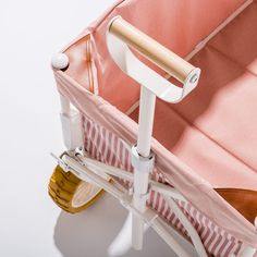 a pink and white suitcase sitting on top of a table