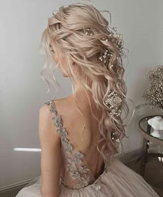 the back of a woman's head with long blonde hair and flowers in her hair