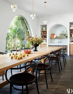 a long table with chairs and fruit on it