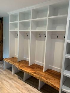 an empty room with white shelves and wooden benches