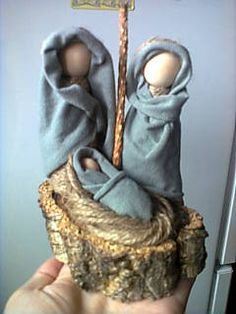 a hand holding a small statue with two cloths on it