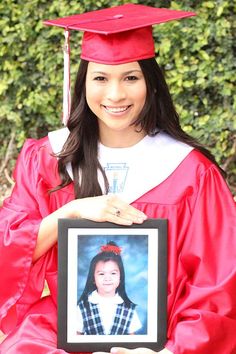 a woman in graduation gown holding up a framed photo