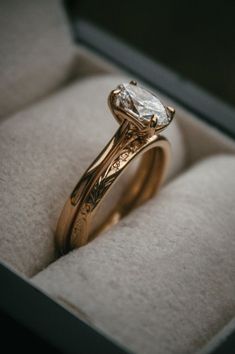 a close up of a ring in a box with a diamond on the top and bottom