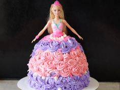 a barbie doll cake with pink, purple and lavender frosting on the top tier