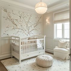 a baby's room with a white crib and tree mural