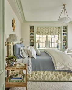 a bedroom with green walls and white bedding in the center, along with two lamps on either side of the bed