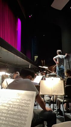 the conductor is directing an orchestra with sheet music