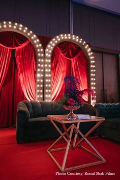 a living room decorated with red curtains and lights