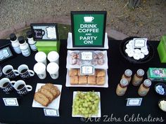 a table topped with food and drinks on top of a black tablecloth covered ground