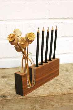 a wooden holder with pencils and flowers in it