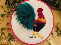 a colorful rooster on a white and red hoop