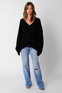 STYLE INFORMATION: The Leila Black V-Neck Oversized Sweater is the sweater of the season! Black knit fabric shapes an oversized sweater with a V-neckline and long, relaxed sleeves. Features ribbed knit neckline, cuffs, and hemline. DETAILS & CARE: Acrylic. Hand wash cold. Imported. SHIPPING: We offer free shipping for all orders in the Continental US. Oversized V Neck Sweater Outfit, Oversized Black Sweater Outfit, Jumper Outfit Women, 30 Piece Wardrobe, Oversized Black Knit Sweater, Uni Outfit Ideas, Black Sweatshirt Outfit, Cute Oversized Sweater, Black Sweater Outfit