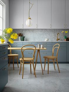 a kitchen with gray cabinets and yellow flowers