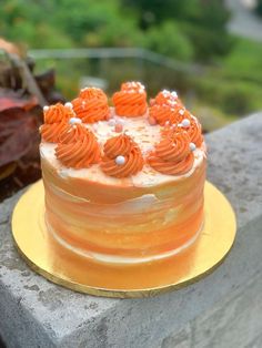 an orange frosted cake sitting on top of a yellow plate