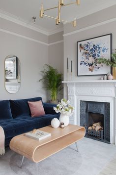 a living room filled with furniture and a fire place in front of a painting on the wall