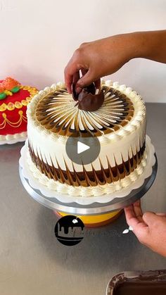 someone is decorating a cake with chocolate icing