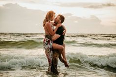 a man and woman kissing in the ocean