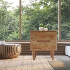 a wooden cabinet sitting on top of a hard wood floor next to a large window