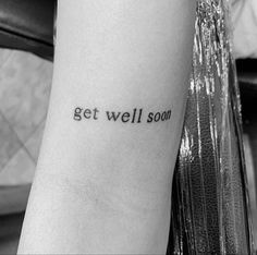 a person with a tattoo on their arm that says get well soon in black ink