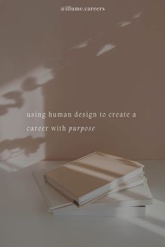 two books sitting on top of each other in front of a wall with the words using human design to create a career with purpose