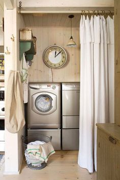 a washer and dryer sitting in a room next to a clock on the wall