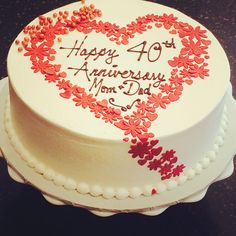 a white cake decorated with red flowers and the words happy 40 th anniversary mom - in - law