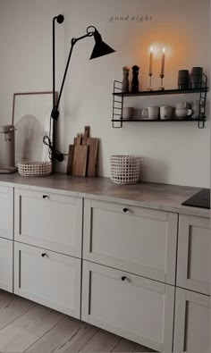 a kitchen with white cabinets and black lighting