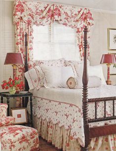 a bed sitting in a bedroom next to a window covered in red and white curtains